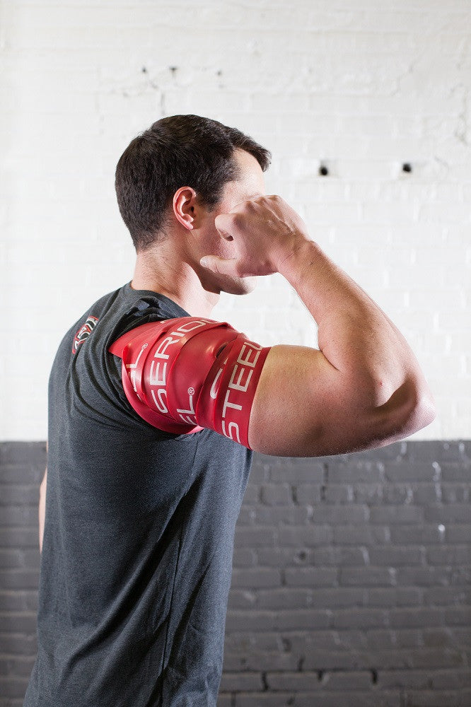 A man using Mobility Bands from Serious Steel Fitness on his shoulder.